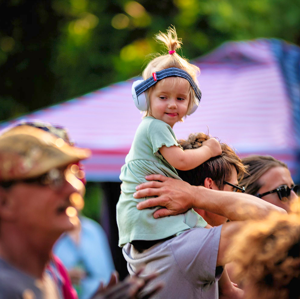 little girl watching blues and jazz on dad's shoulders